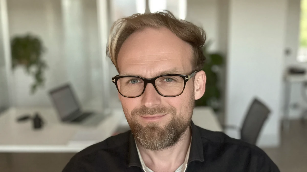 Derselbe KI-Avatar im hellen modernen Büro — digitaler Zwilling im Co-Working-Setting